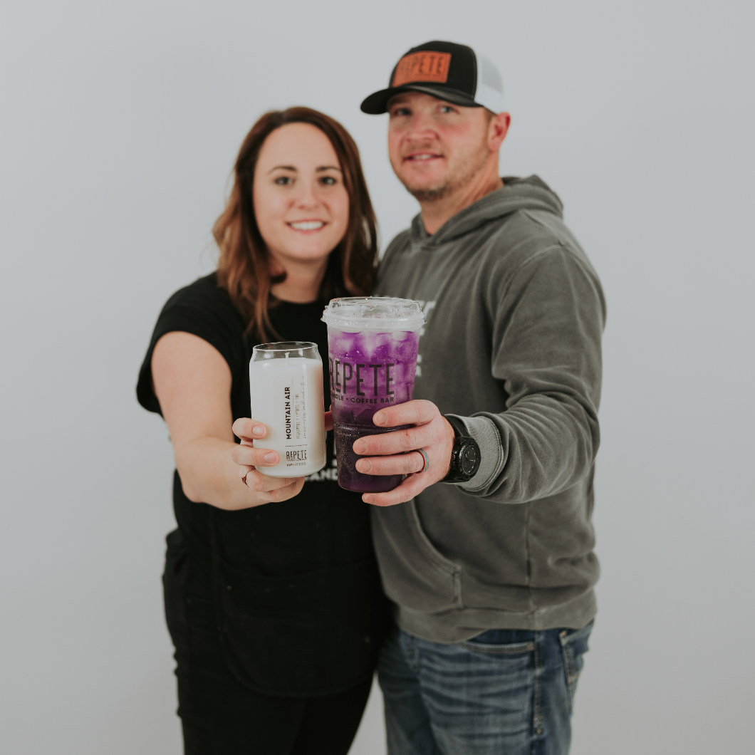 Repete Candle and Coffee Bar owners holding a candle and a lotus drink